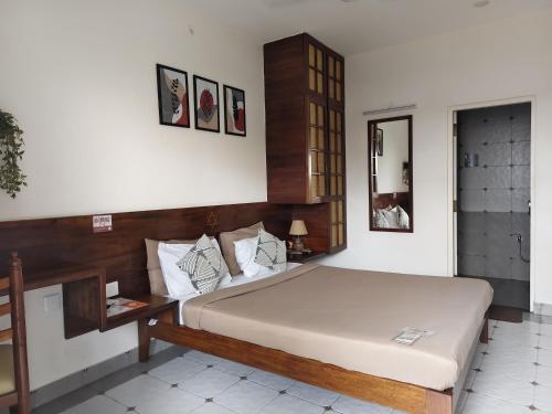 a bedroom with a large bed and a mirror at Casa Mel in Puducherry