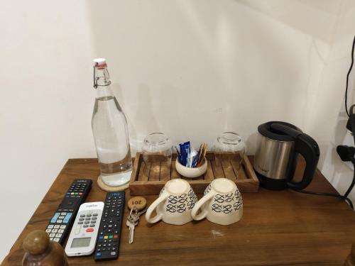 a wooden table with a bottle and a remote control at Casa Mel in Puducherry