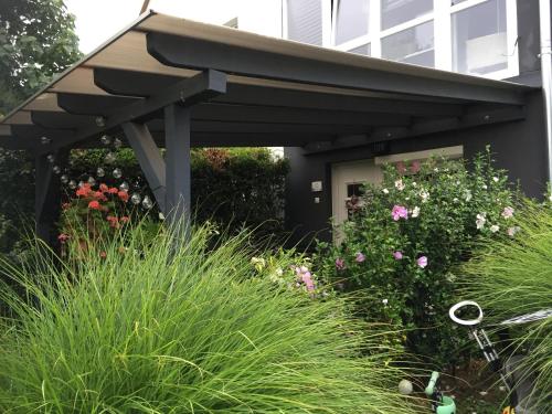a black awning in front of a building with flowers at Home Apartman in Nagyesztergár