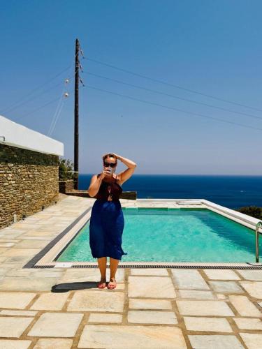 a woman taking a picture of a swimming pool at Harma Villas in Andros