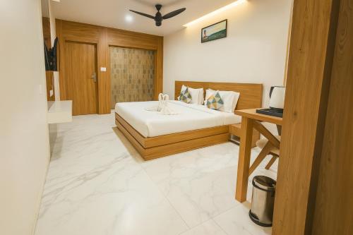 una camera da letto con un letto e una scrivania con un computer portatile di The Sky Imperial Unity Inn a Garudeshwar
