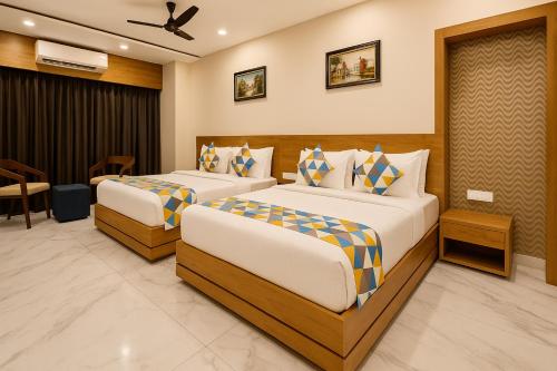 una camera d'albergo con due letti in una stanza di The Sky Imperial Unity Inn a Garudeshwar