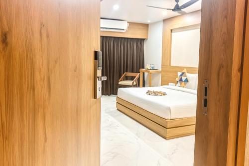 a door leading to a bedroom with a bed at The Sky Imperial Unity Inn in Garudeshwar