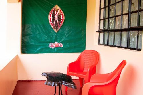 two red chairs and a table in a room at KAREN Comfort 3BR Holiday Home Nandi Rd off Miotoni in Nairobi