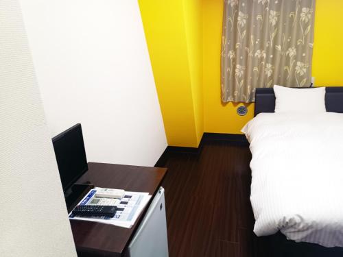 a bedroom with a bed and a desk with a computer at Ace Inn Asakusa in Tokyo