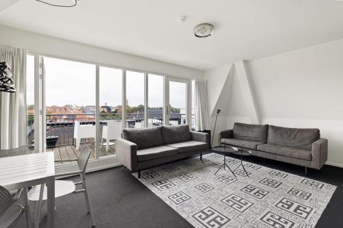 a living room with two couches and a table at B's Strandappartementen in Domburg