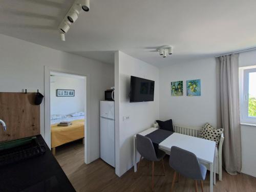 a small room with a white table and chairs at Casa di Castello in Mali Lošinj