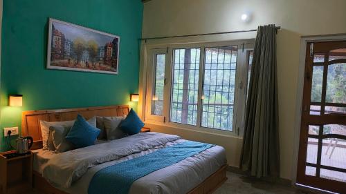 a bedroom with a bed with green walls and a window at Neelkanth Cozy Stays Mukteshwar in Mukteswar