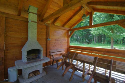 a porch of a log cabin with a fireplace at Horská chata Jelšinky v Národnom parku Slovenský raj in Smižany