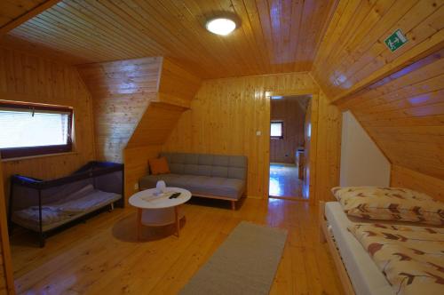 a room with a couch and a table in a cabin at Horská chata Jelšinky v Národnom parku Slovenský raj in Smižany