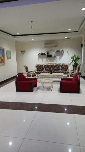 a living room with two red chairs and a table at Wisma Davinci Sabrina in Jakarta
