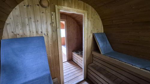 a small wooden cabin with a blue bench in it at Cozy, private country home with a garden and sauna 