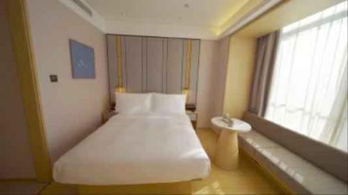 a bedroom with a large white bed and a window at JI Hotel Beijing Zhongguancun Renmin University Subway Station in Beijing