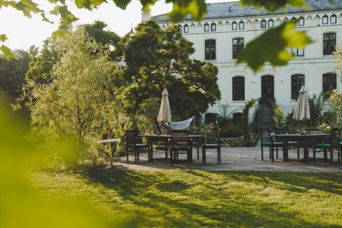 a garden with tables and umbrellas in front of a building at Wohnung Wilhelm in Behren-Lübchin
