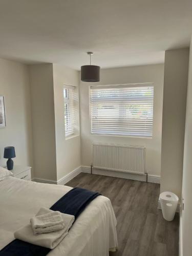 a white bedroom with a bed and two windows at Seaview House with Sea View Brand New- 3 Bedrooms - Harwich, Dovercourt in Lancing