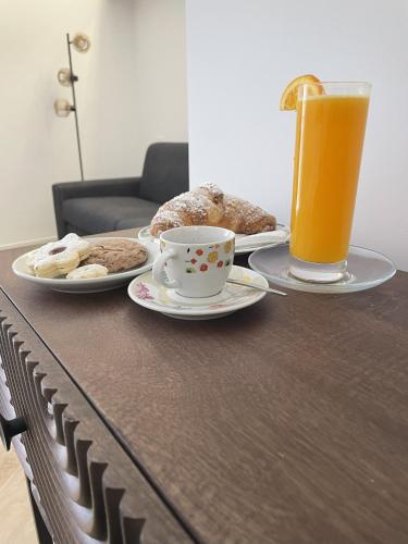 a table with two plates of food and a cup of orange juice at Ca' Semu in Catania