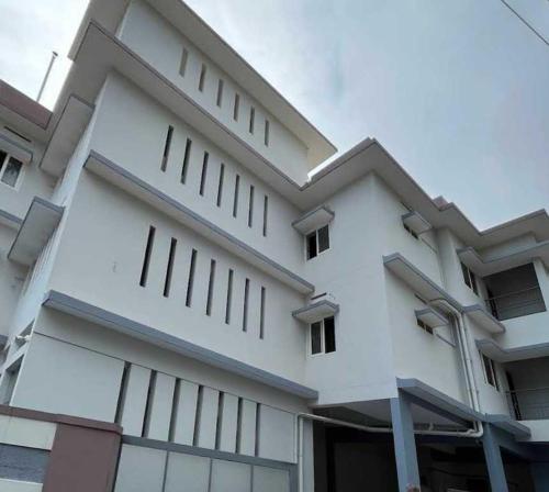 a white building with a lot of windows at Collection O Kallai Railway Junction in Kozhikode