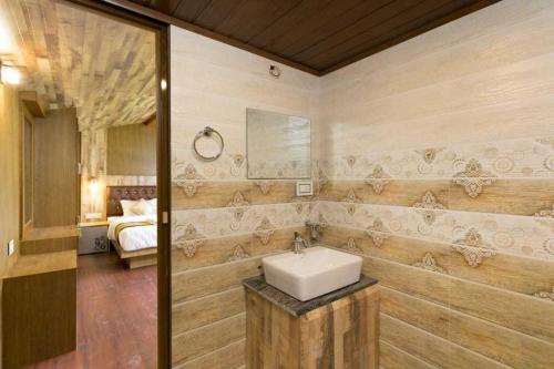 a bathroom with a sink and a bed in a room at Collection O Kallai Railway Junction in Kozhikode