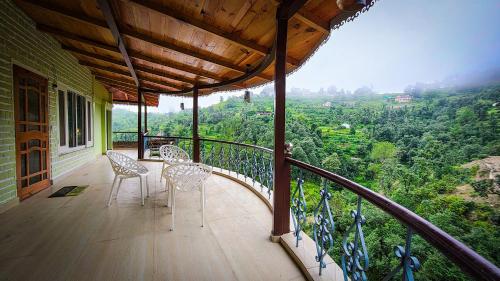a balcony with chairs and a view of a valley at Neelkanth Cozy Stays Mukteshwar in Mukteswar