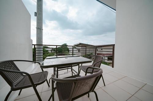 a patio with chairs and a table on a balcony at Picturesque 3BR home near Thunderbird, Overlooking in Binangonan