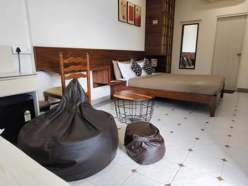 a bedroom with two beds and a bag on the floor at Casa Mel in Puducherry