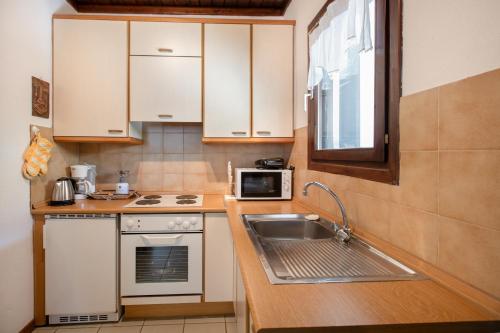 una piccola cucina con lavello e microonde di Ergastiri Retreat by RentalsPro - Trikorfo Halkidiki a Yerakiní