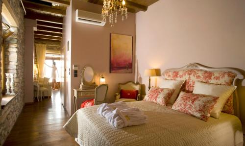 a bedroom with a bed and a chandelier at Minelska Apartments in Kala Nera