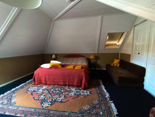 a bedroom with a bed and a couch at Casa Elburg in Elburg