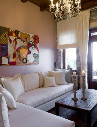 a living room with a white couch and a chandelier at Minelska Apartments in Kala Nera