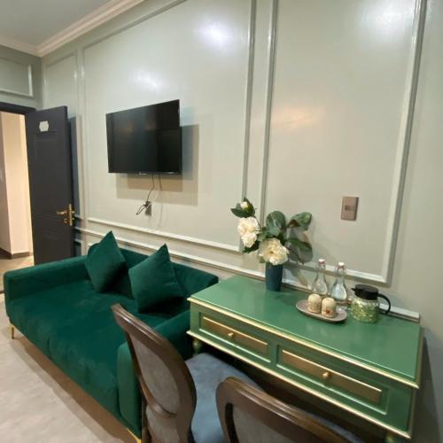 a living room with a green couch and a table at Eco Bliss Hotel in Thôn Lại Thê
