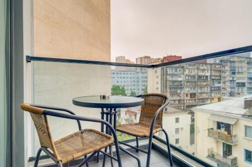 a table and two chairs on a balcony with a view at Hotel Salvador in Batumi