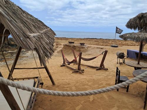 a sandy beach with chairs and umbrellas and the ocean at Vivenda Mia in Beirona