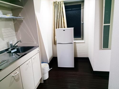 a white refrigerator in a kitchen with a window at Ace Inn Asakusa in Tokyo
