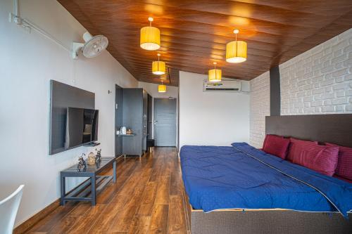 a bedroom with a bed with blue sheets and red pillows at Celeste Vista by Chirping Hills in Bhīm Tāl