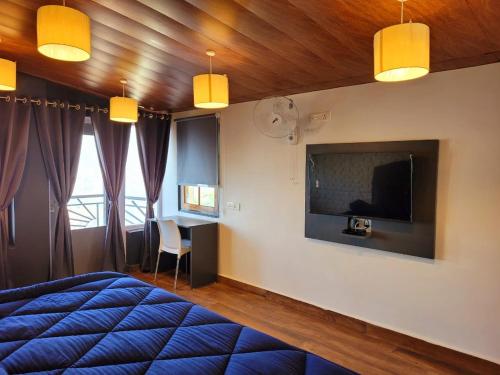 a bedroom with a bed and a tv on the wall at Celeste Vista by Chirping Hills in Bhīm Tāl