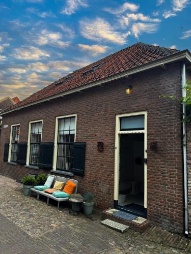 a brick building with a bench with pillows on it at Casa Elburg in Elburg
