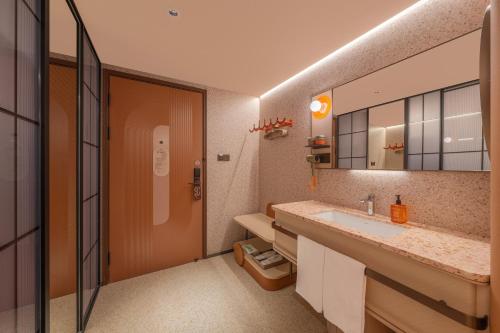 a bathroom with a sink and a mirror at Orange Hotel Beijing Liangxiang University Town in Beijing