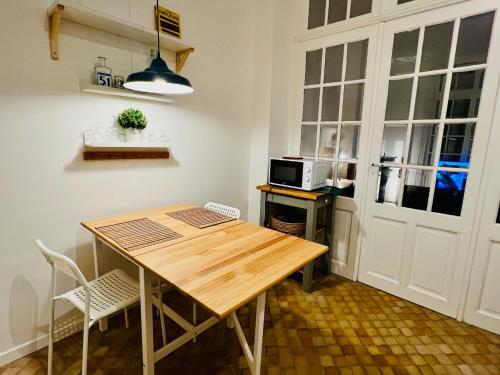 a kitchen with a wooden table and a microwave at T2 avec beaucoup de cachet in Saint-Quentin