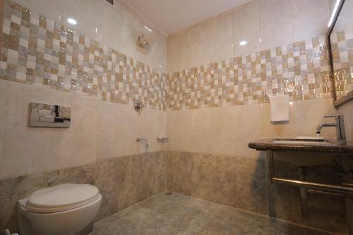 a bathroom with a toilet and a sink at Nakshatra Hotel in Bānswāra