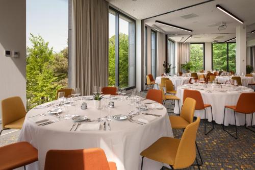 a conference room with white tables and chairs and windows at Melia Luxembourg in Luxembourg