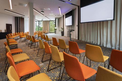 a lecture room with chairs and a projection screen at Melia Luxembourg in Luxembourg