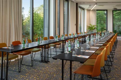 a row of tables and chairs in a room with windows at Melia Luxembourg in Luxembourg
