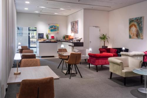 a waiting room with tables and chairs and a counter at Melia Luxembourg in Luxembourg