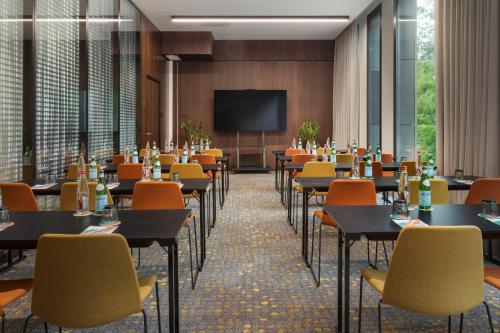a conference room with tables and chairs and a projection screen at Melia Luxembourg in Luxembourg