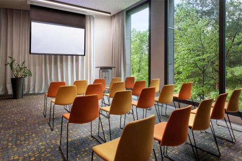 a conference room with chairs and a projection screen at Melia Luxembourg in Luxembourg