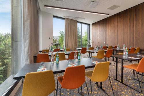 a conference room with tables and chairs and windows at Melia Luxembourg in Luxembourg