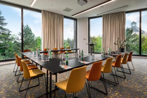 a conference room with long tables and chairs and large windows at Melia Luxembourg in Luxembourg