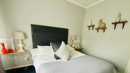 a bedroom with a white bed with a large headboard at Follyfoot Manor in Midrand