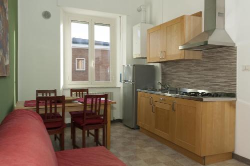 a kitchen with a table and chairs and a kitchen with a refrigerator at Viale Mezzetti - 1.3 by Ospitaci in Foligno