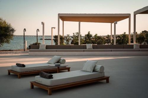 two couches and tables on a patio near the water at Villa Julia in Manfredonia